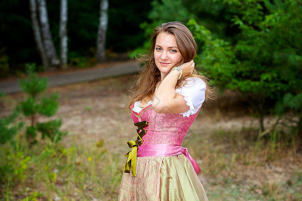 迪恩德尔年轻女子站在森林中微笑的画像