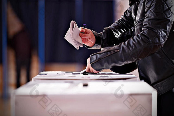 在选举期间，手持邮票将选票投进投票箱的手