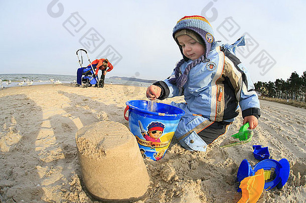 冬天在沙滩上玩耍的小男孩