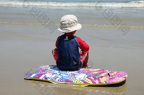 这是一张小冲浪者的照片，他正在等待大浪，一天的浪，十年的浪！