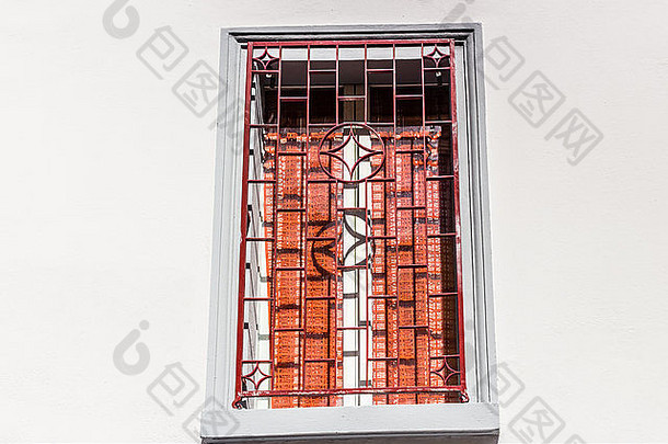 红色的铁光栅灰色广场窗口白色木框架红色的窗帘