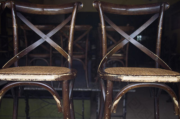 特写镜头饱经风霜的棕色（的）木椅子堆放空房间