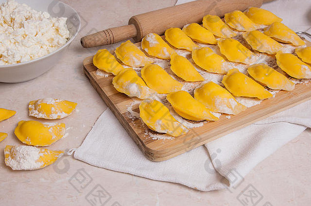 准备好了沸腾瓦雷尼基饺子饺子小屋奶酪凝乳木切割董事会面粉新鲜的准备黄色的滚