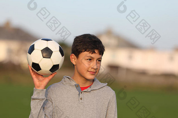 日落前的黄金时段，男孩拿着足球在外面