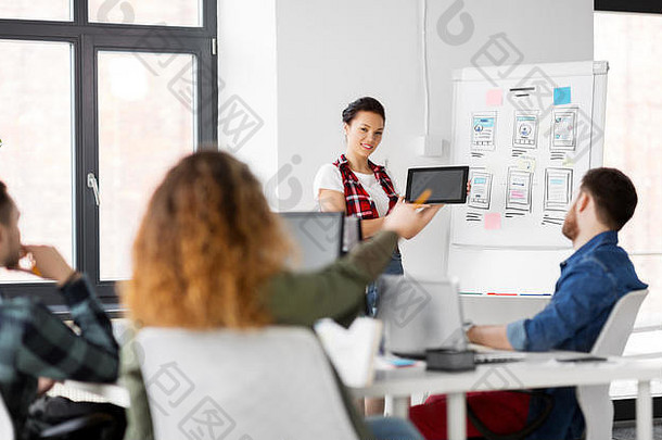 女士在办公室向创意团队展示平板电脑