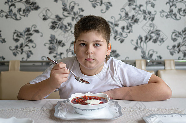 男孩少年在厨房餐桌上喝汤