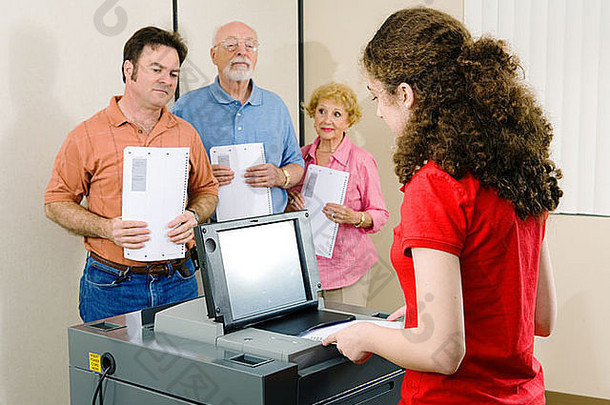 排队等候的年轻女子在光学扫描机上投票