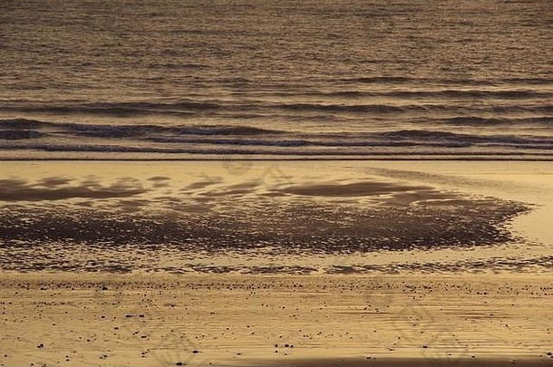 英国苏格兰阿伯丁，黎明金光中平静的北海低潮时复杂的溪流沙纹。
