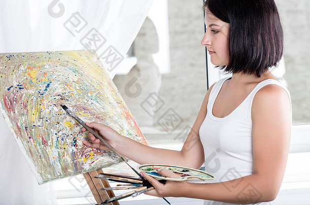 年轻的女人画架油漆图片