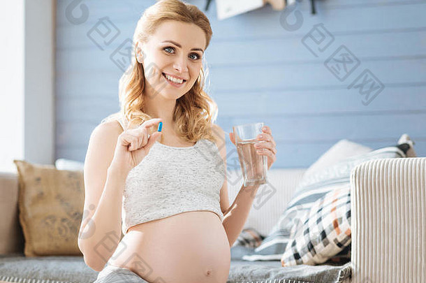 怀孕了女人展示药丸玻璃水