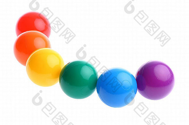 六个闪亮的彩色塑料玩具球排成一排，分别放在白色的地板上。可用的文本空间和空间