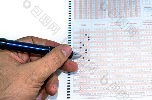 男子手记，用铅笔在考试成绩表上填写答案和答案。