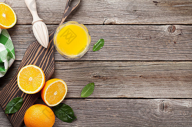 橙子和<strong>果汁</strong>杯放在木桌上。具有空间的俯视图