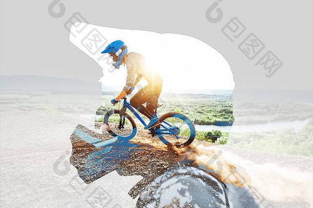 一个戴着防护头盔的男子和骑在山上的职业自行车手的双重曝光。免费乘车和越野自行车的概念