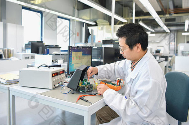 工作中的亚洲工程师-在现代化工厂进行电子和开发