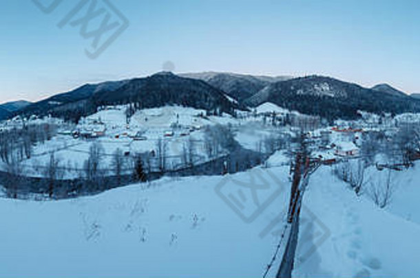 黎明黄昏冬日喀尔巴阡山村泽琳在黑切雷莫什河谷阿尔卑斯山之间。从小山上被雪覆盖的小径上看去