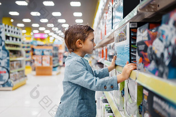 儿童商店货架上的小男孩，侧视图