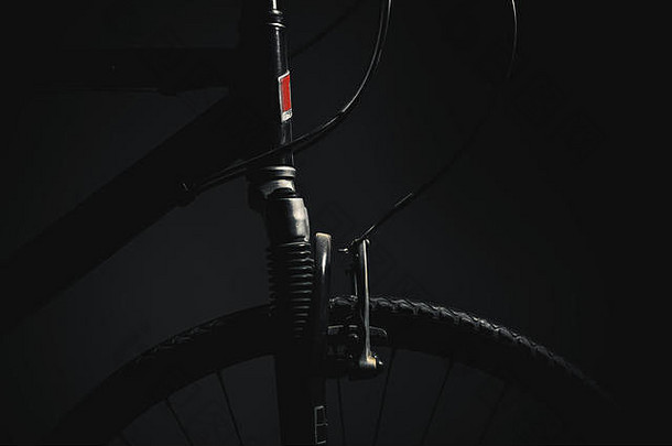 自行车车轮特写视图，深色背景和强烈的高光。