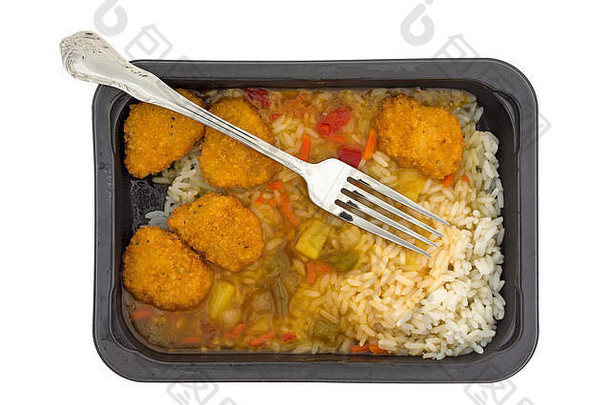 在白色背景下，一个黑色塑料托盘中的糖醋鸡和一个叉子在食物中被隔离，这是一顿新鲜烹制的<strong>电视</strong>晚餐的俯视图。