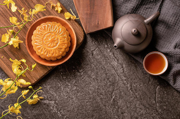 <strong>中秋</strong>节传统美食理念——美丽的月饼放在黑石板桌上，有茶水、糕点模具、鲜花、顶视图、平面<strong>布置</strong>、临摹空间