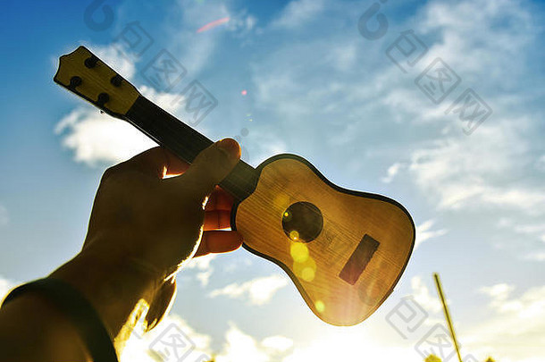 日落时，音乐家们在天空中拿着吉他。成功理念