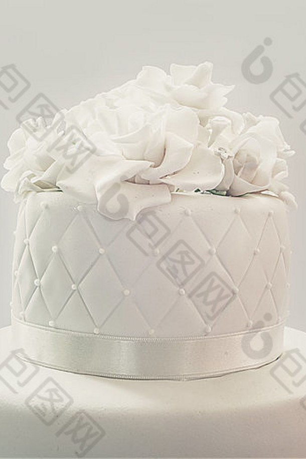 婚礼蛋糕的细节，在白色背景上用白色软糖装饰。