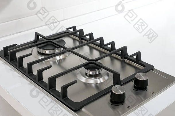 现代不锈钢银色<strong>燃气灶</strong>，带有黑色元素和燃烧器，位于白色厨房设备表面上方视图
