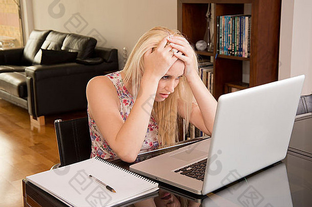一名正在使用笔记本电脑的年轻女子因<strong>失去工作</strong>而崩溃