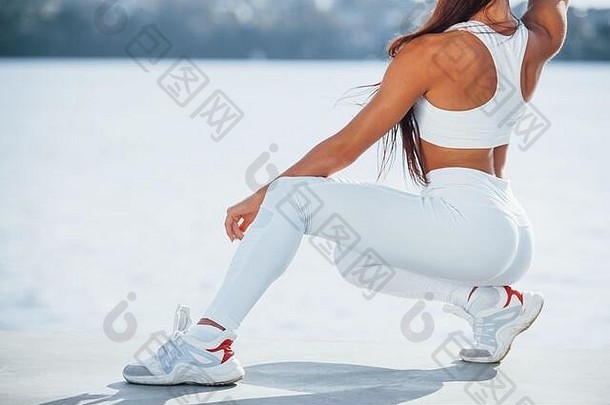 白天在湖边锻炼身体的运动型女子的照片