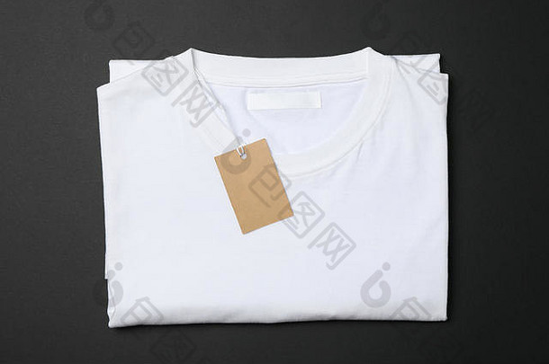 折叠空白白色t恤，黑色背景上有标签，空白处有文字