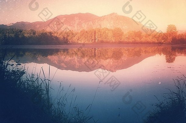 在夕阳下，山在池塘的静水中完美地反射