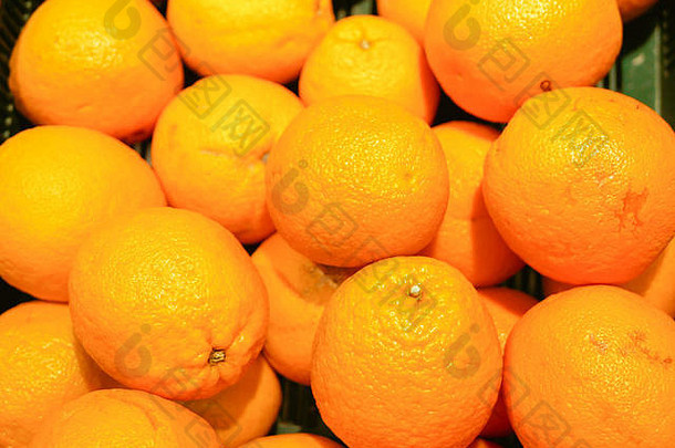 柜台上有成熟的橙子。在商店橱窗里收集一个橘子。特写镜头。新年水果概念，鲜榨维生素果汁