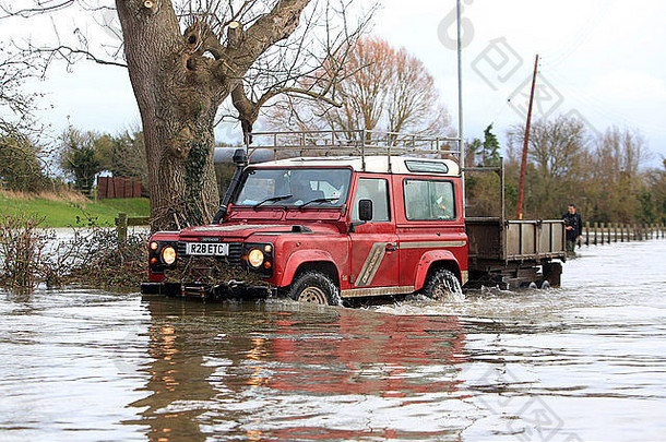萨默塞特伯罗布里奇的居民使用拖拉机和路虎车穿过上涨了4英尺的洪水。
