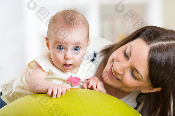 妈妈。孩子练习体操球概念有爱心的婴儿的健康
