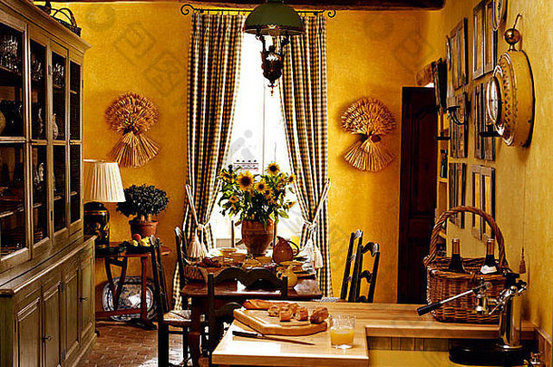 明亮的黄色法国乡村厨房餐厅里的大型彩绘梳妆台，窗户上有格子窗帘