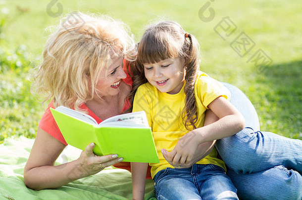 母亲夏天在户外给孩子读书