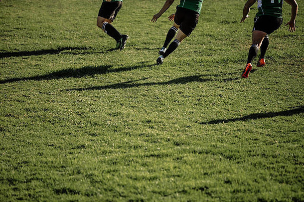 橄榄球运动员在比赛中在场上奔跑。职业橄榄球运动员在球场上比赛时的脚。