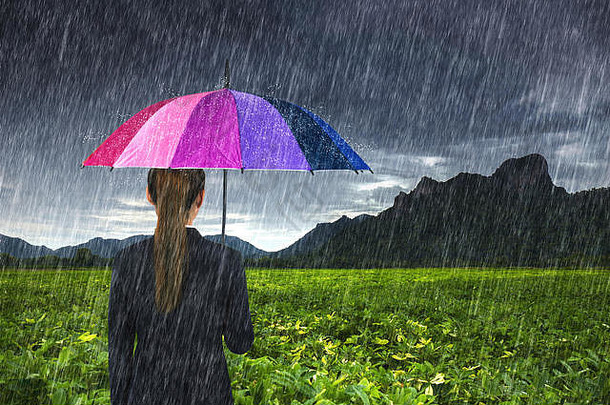 泰国罗布里考珍莱，一名手持五彩雨伞的女商人正在下雨