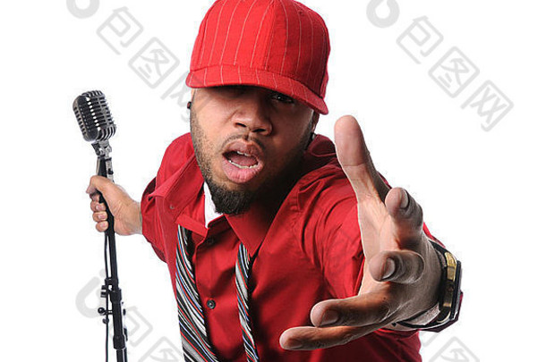 一名非洲裔美国男子身穿红色衬衫，戴着帽子，手持老式麦克风唱歌