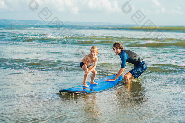 父亲教练教学<strong>一</strong>年儿子冲浪海假期假期旅行体育孩子们概念冲浪教训孩子们