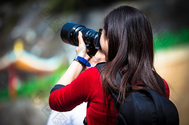 年轻的女孩中间摄影行动专业数码单反相机