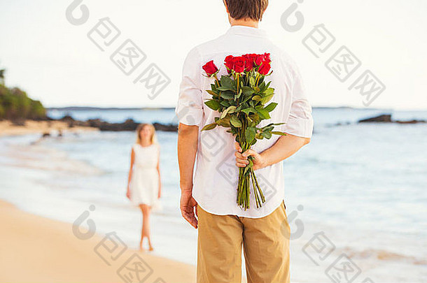 年轻的夫妇爱男人。持有惊喜花束玫瑰美丽的年轻的女人浪漫的日期