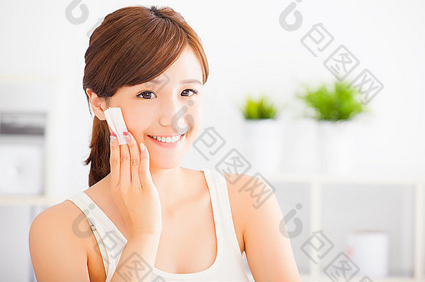 美丽的亚洲年轻的女人清洁脸棉花