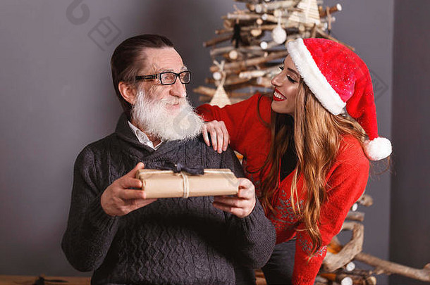 汉森高级爸爸白色胡子穿眼镜灰色的毛衣礼物年轻的长头发的女儿红色的毛衣穿圣诞老人他一年圣诞节假期记忆礼物购物折扣商店雪少女圣诞老人老人化妆发型狂欢节