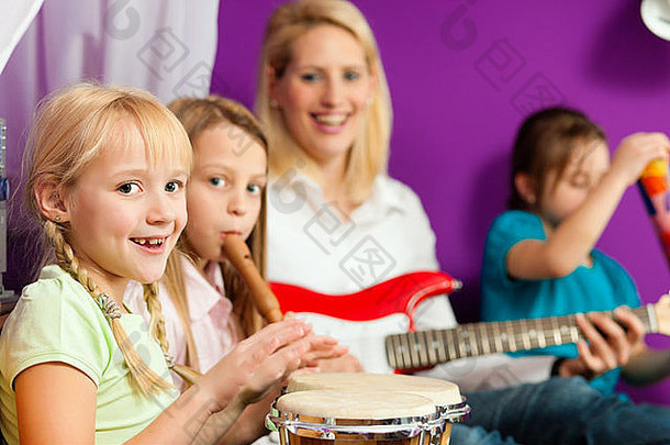家庭孩子们妈妈。使音乐练习玩吉他邦戈长笛