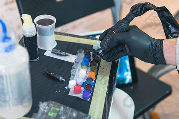 特写镜头纹身艺术家工作的地方部分油漆机器设备专业文身的人工作纹身工作室过程麦