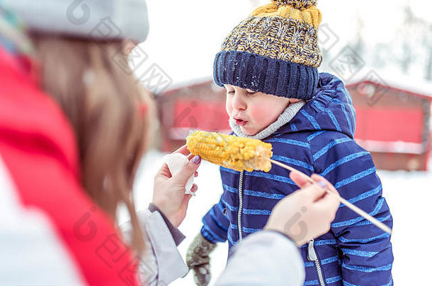 女孩妹妹提要哥哥儿子年手持有煮熟的玉米坚持冬天城市城市假期周末