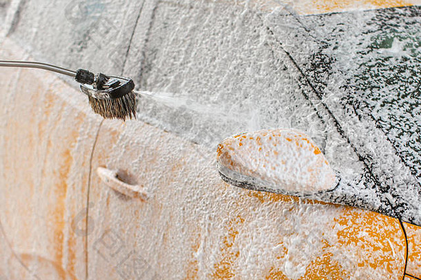黄色的车洗服务洗车洗发水泡沫喷涂一边镜子窗口