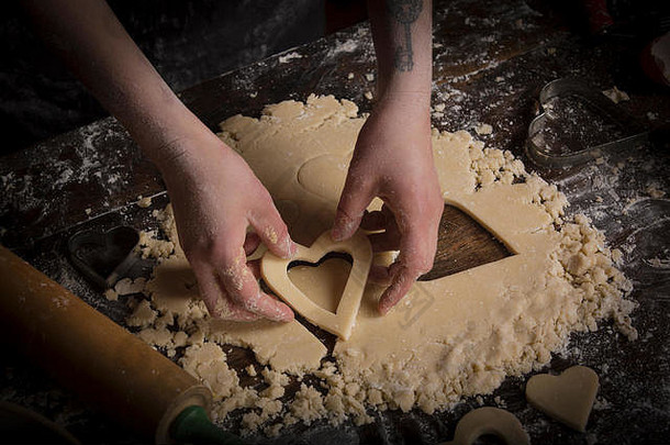情人节一天<strong>烘焙</strong>女人切割心形状的饼干面团