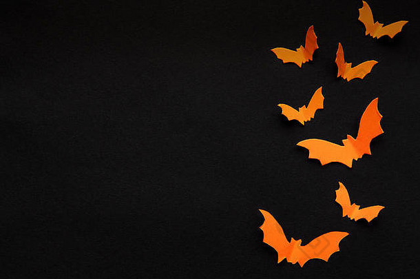万圣节概念橙色纸蝙蝠飞行黑色的背景